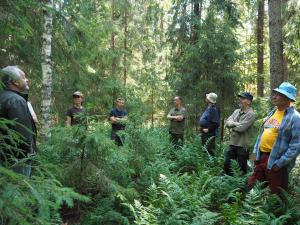 En grupp människor står i en ring i skogen.