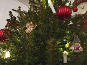 En gran klädd i julgransprydnader.