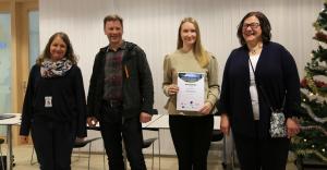 Puuta siltaan -ideakilpailun voittanut Mette Perkiö pitelee kunniakirjaa.