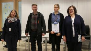 Puuta meluseinään -ideakilpailun voittaja Pauliina Haukipuro kunniakirjan kanssa.