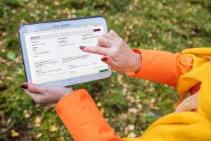 Henkilö katsoo Metsään.fin hakemusta tabletilla.