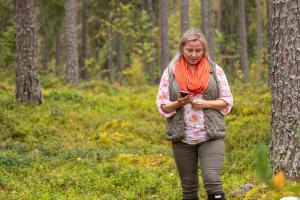 en person går i skogen med en telefon i handen