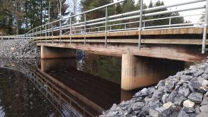 Peruskorjattu puusilta, jonka alla on vettä. 