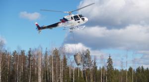En helikopter sprider aska från luften.