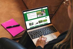 En person tittar på Skogscentralens öppna e-kurser på en bärbar dator i soffan.