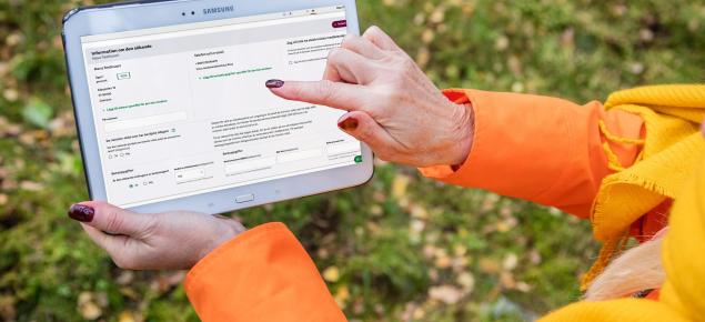 Person tittar på stödansökan i MinSkog.fi på en surfplatta.