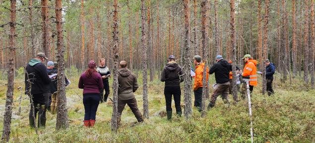 Människor i torvmarksskog på terrängutbildning.  