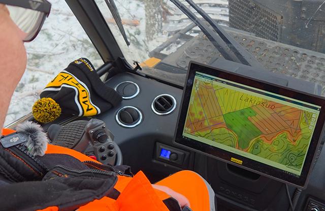 Henkilö ajaa metsäkonetta.